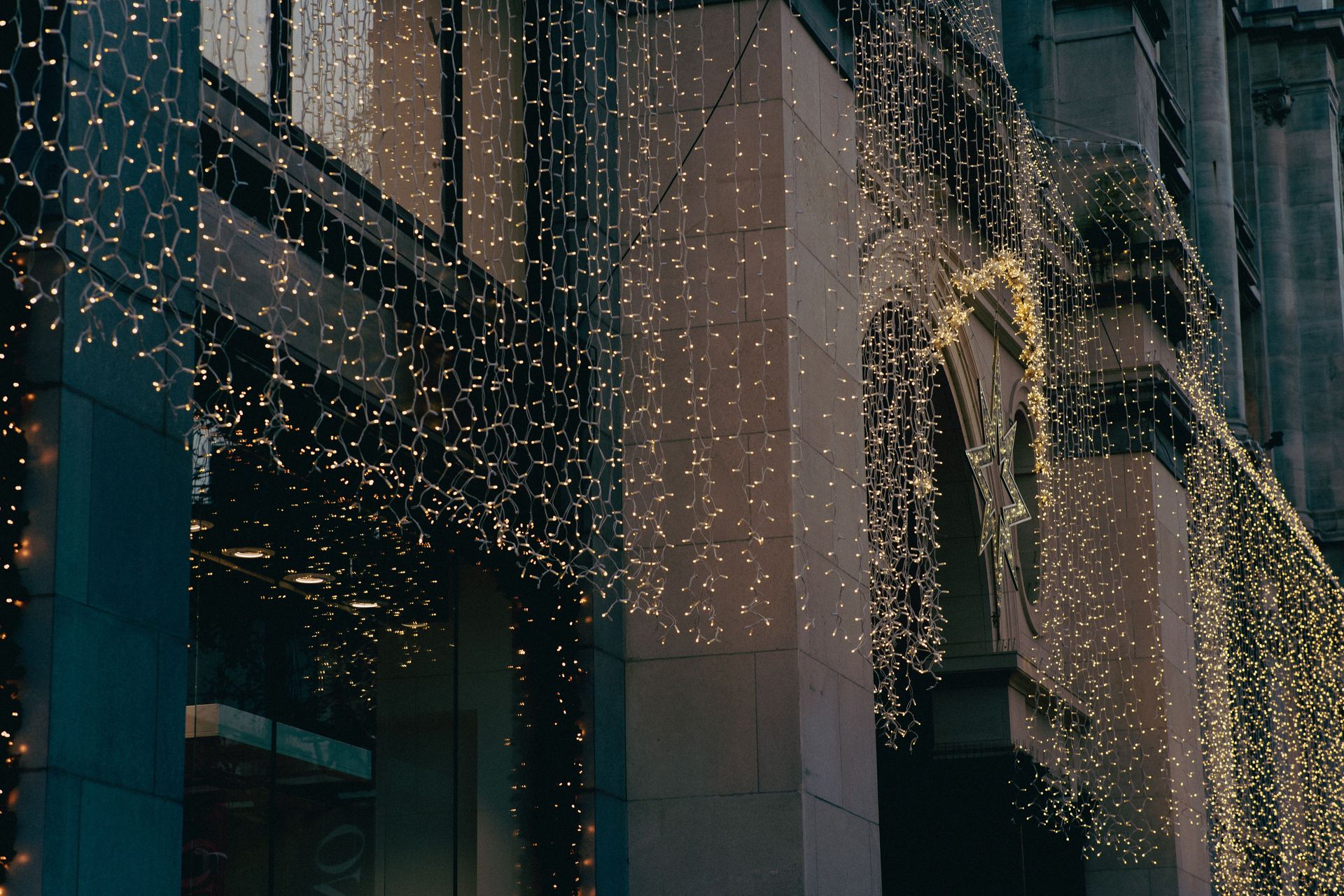 Warm festive lights decorating a city's building facade during the holiday season in Antwerp.